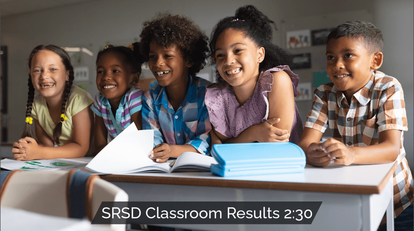 Group of happy elementary students in a classroom, symbolizing the positive impact of SRSD on classroom results.