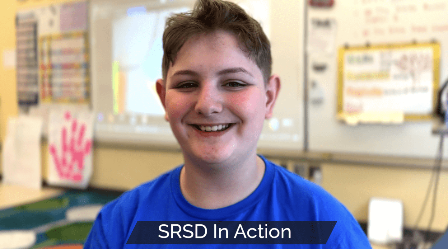 Smiling student in a classroom, with the title, “SRSD In Action,” and the video time of three minutes.