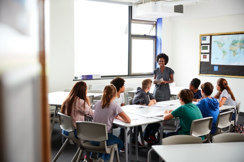 A teacher leading an interactive discussion with a group of engaged students in a modern classroom.