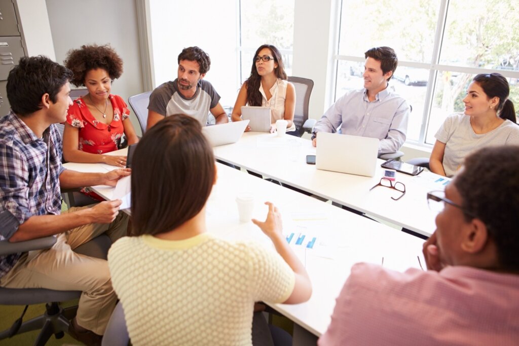Diverse team collaborating in a modern conference room with laptops and documents